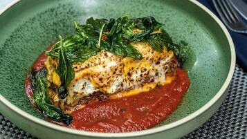 Ein Teller mit einer grünen Schüssel auf einer gewebten Tischdecke.