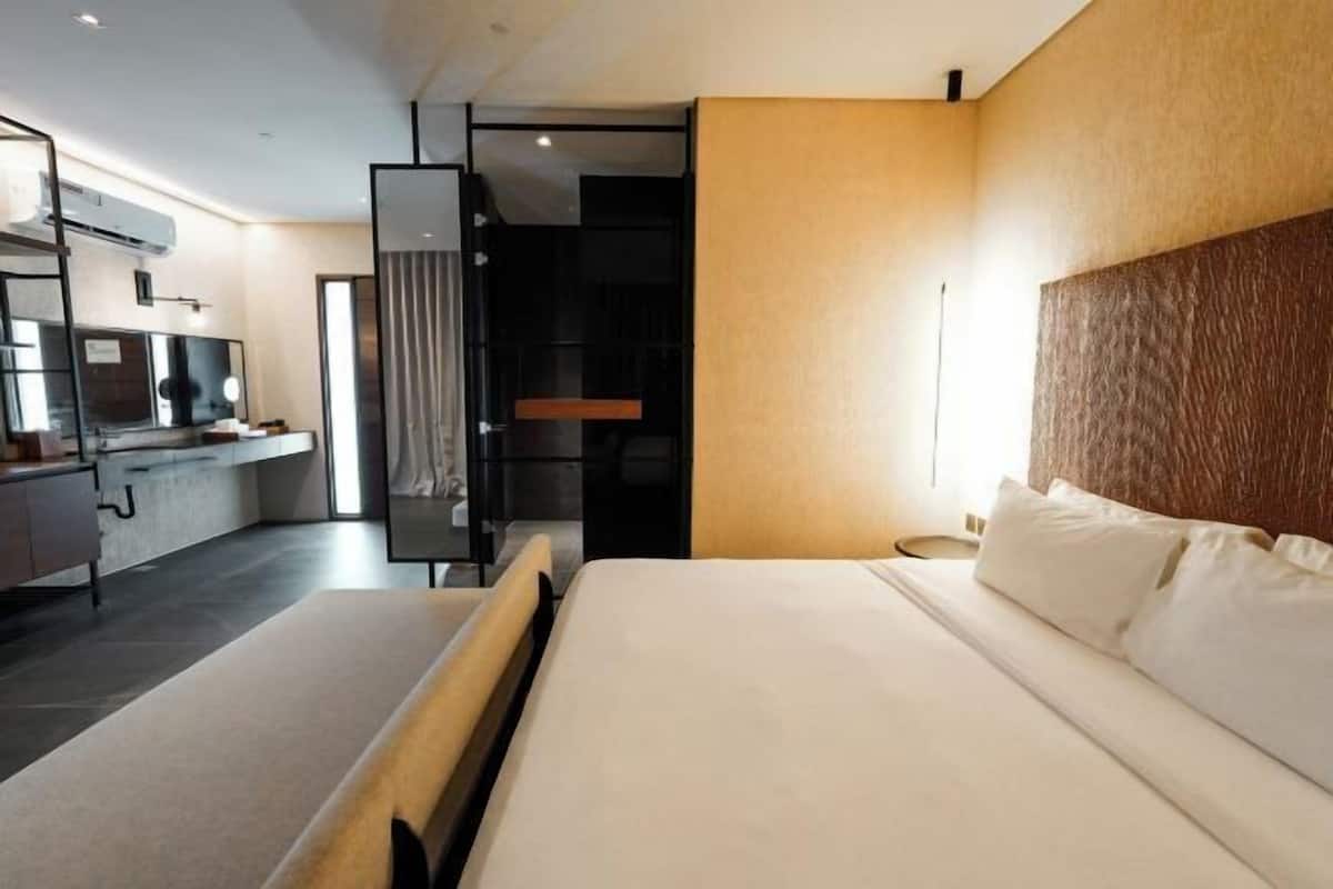 Ein modernes Hotelzimmer mit einem großen Bett, einem Schreibtisch und einem Spiegel.