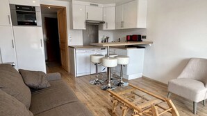 A modern apartment with a living room, a kitchen, and a dining area.