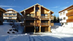 A multi-story wooden building with balconies, surrounded by snow.