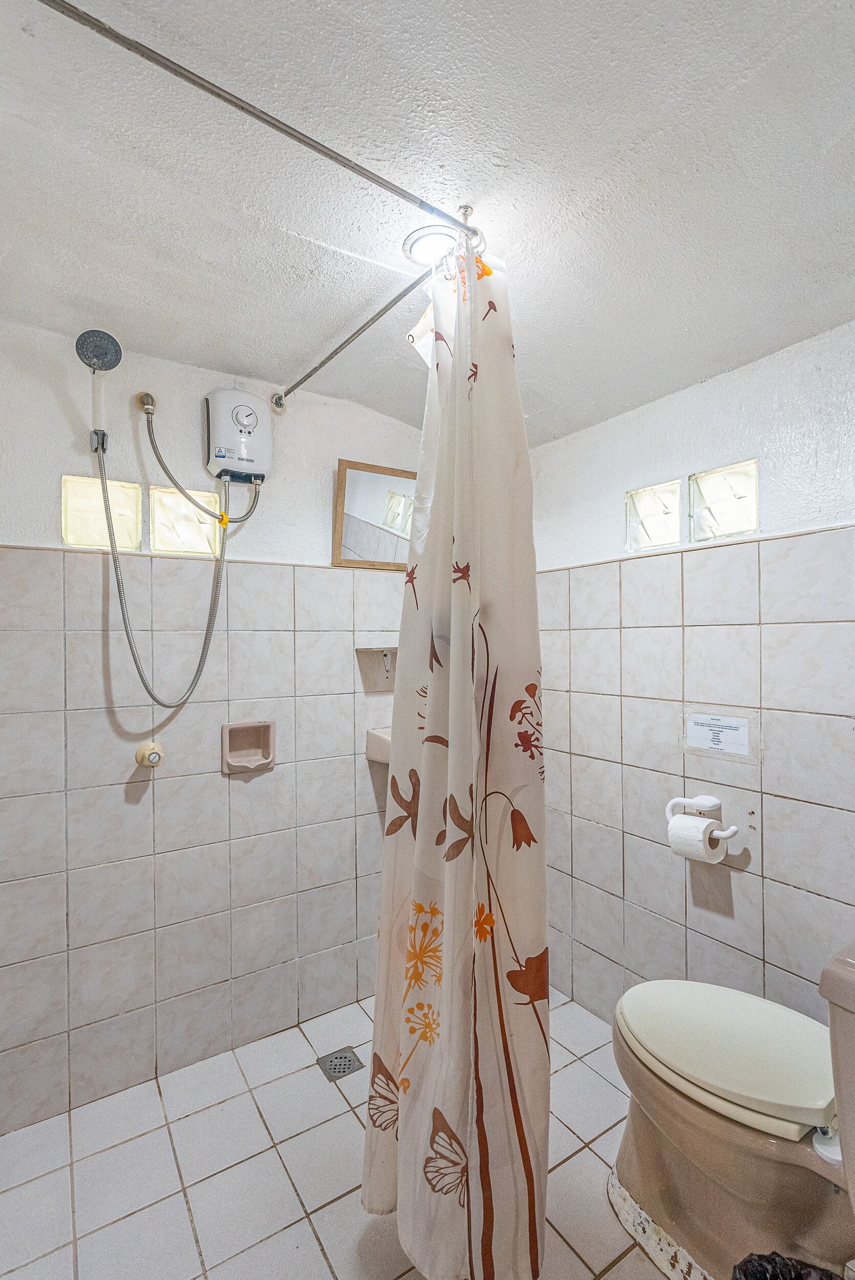 Un baño con ducha, inodoro y barra para toallas.