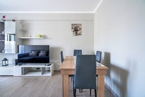 Ein modernes Wohnzimmer mit Fernseher, einem Holzesstisch und einer Couch.