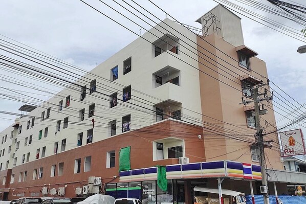 A multi-story building with a flat facade, several windows, and air conditioning units attached to the exterior. - KIM HOTEL AT BANGPLONG  (Samut Prakan)