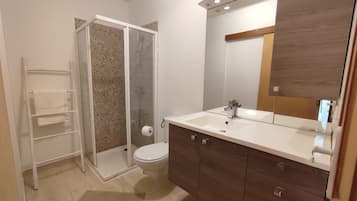Chuveiro, toalhas de banho, sabonete, papel higiênico