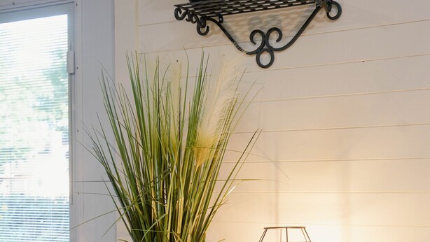 Ein Holzkoffer mit einem Topfpflanzen und einer geometrischen Lampe.