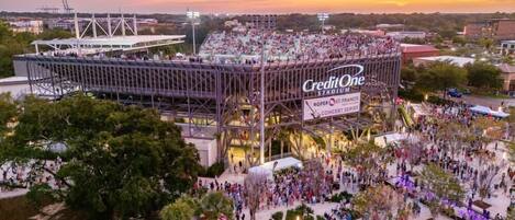 A stadium with a large CreditOne advertisement, surrounded by a crowd of people.