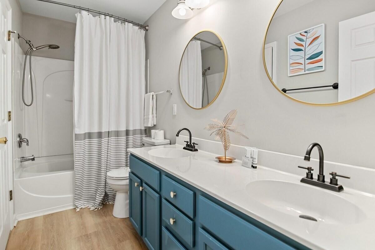 Une salle de bain moderne avec une baignoire, deux lavabos, des toilettes et une douche.