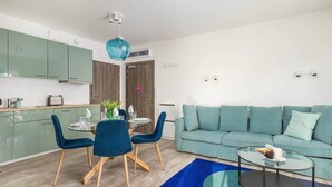 Un espacio habitable moderno con comedor, sofá y mesa de centro.
