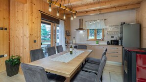 Eine moderne Küche mit Holzausstattung, einem Essbereich mit Tisch und Stühlen und einem roten Kühlschrank.