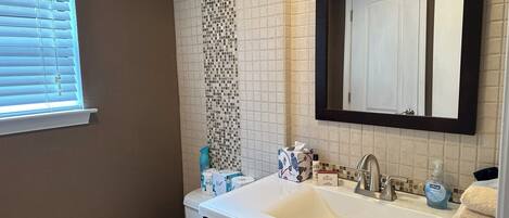 Ein Badezimmer mit Waschbecken, Spiegel und Toilette.