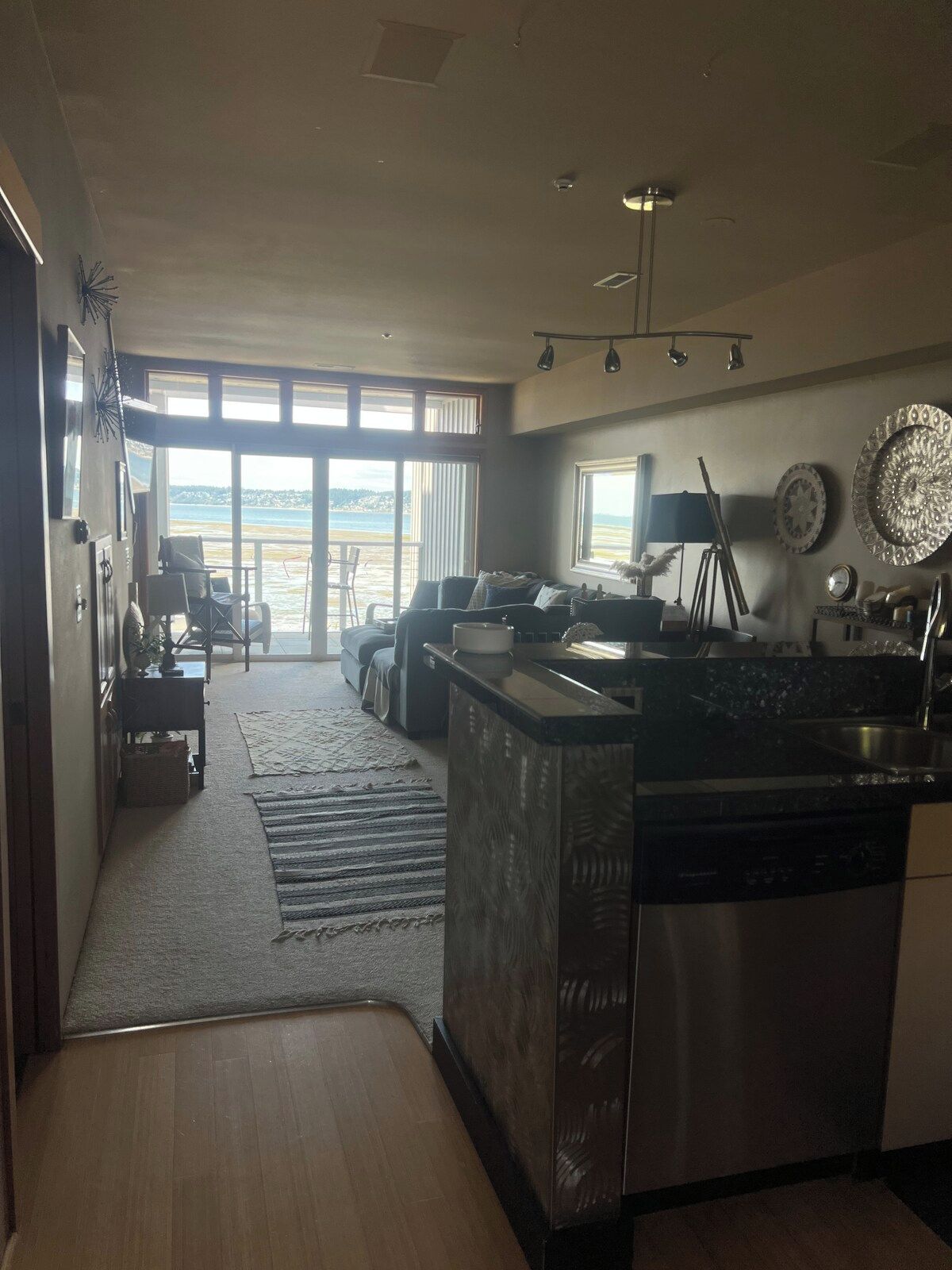 Una cocina moderna con una isla central, un comedor con vistas y un amplio ventanal corredero que da a un balcón.