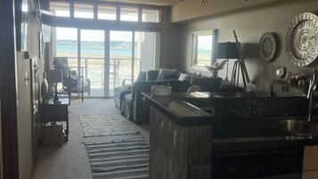 Una cocina moderna con una isla central, un comedor con vistas y un amplio ventanal corredero que da a un balcón.
