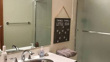 A bathroom with a sink, mirror, towel rack, and a sign that reads 'TWINKLE TWINKLE LITTLE STAR'.
