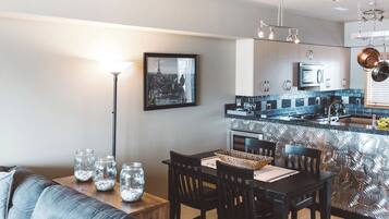 A modern kitchen with a central island, stainless steel appliances, and a pendant light fixture.