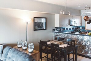 A modern kitchen with a central island, stainless steel appliances, and a pendant light fixture.