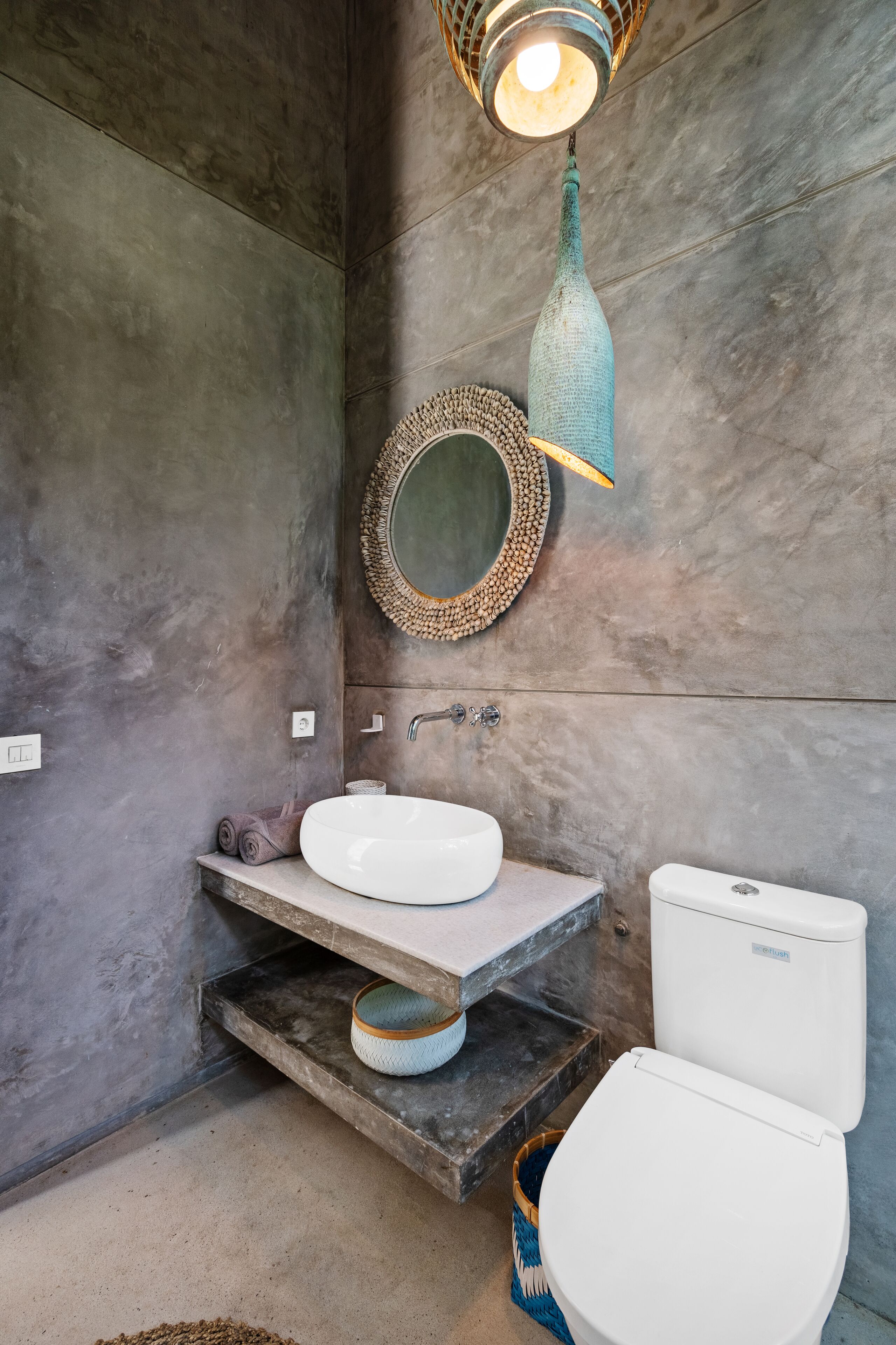 A bathroom with a white sink, a toilet, and a mirror with a decorative frame.