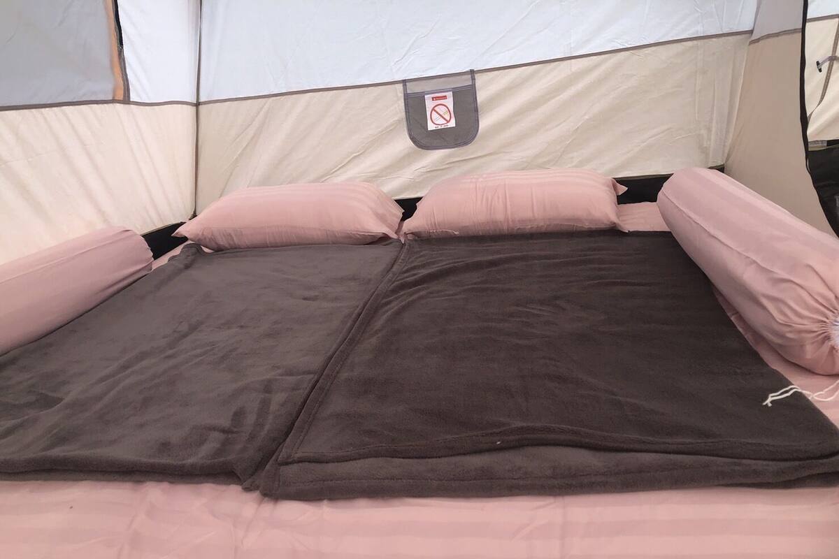 A tent with a bed inside, featuring a tag with a prohibition symbol.