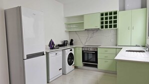 Una cocina moderna con refrigerador, lavadora, horno y lavaplatos.