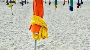 A beach with multiple umbrellas, some covered with cloths, and footprints in the sand. - Standing, Centre, 2 Sdb 2 WC, Balcon, Parking (Deauville)