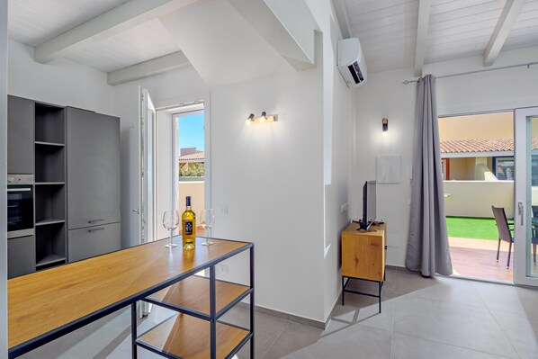 Una cocina moderna con una mesa de madera, un horno empotrado y un armario gris.
