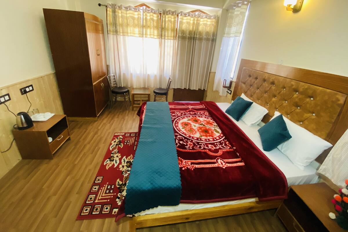 A hotel room with a bed, a desk, and a wardrobe.