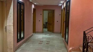 A corridor with pink walls and a tiled floor, leading to a door at the end. - Superbe Appartment en Résidence Avec Piscine (Marrakech)