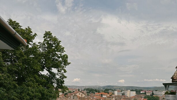 Een terras met rieten meubilair en uitzicht op een stadsbeeld.