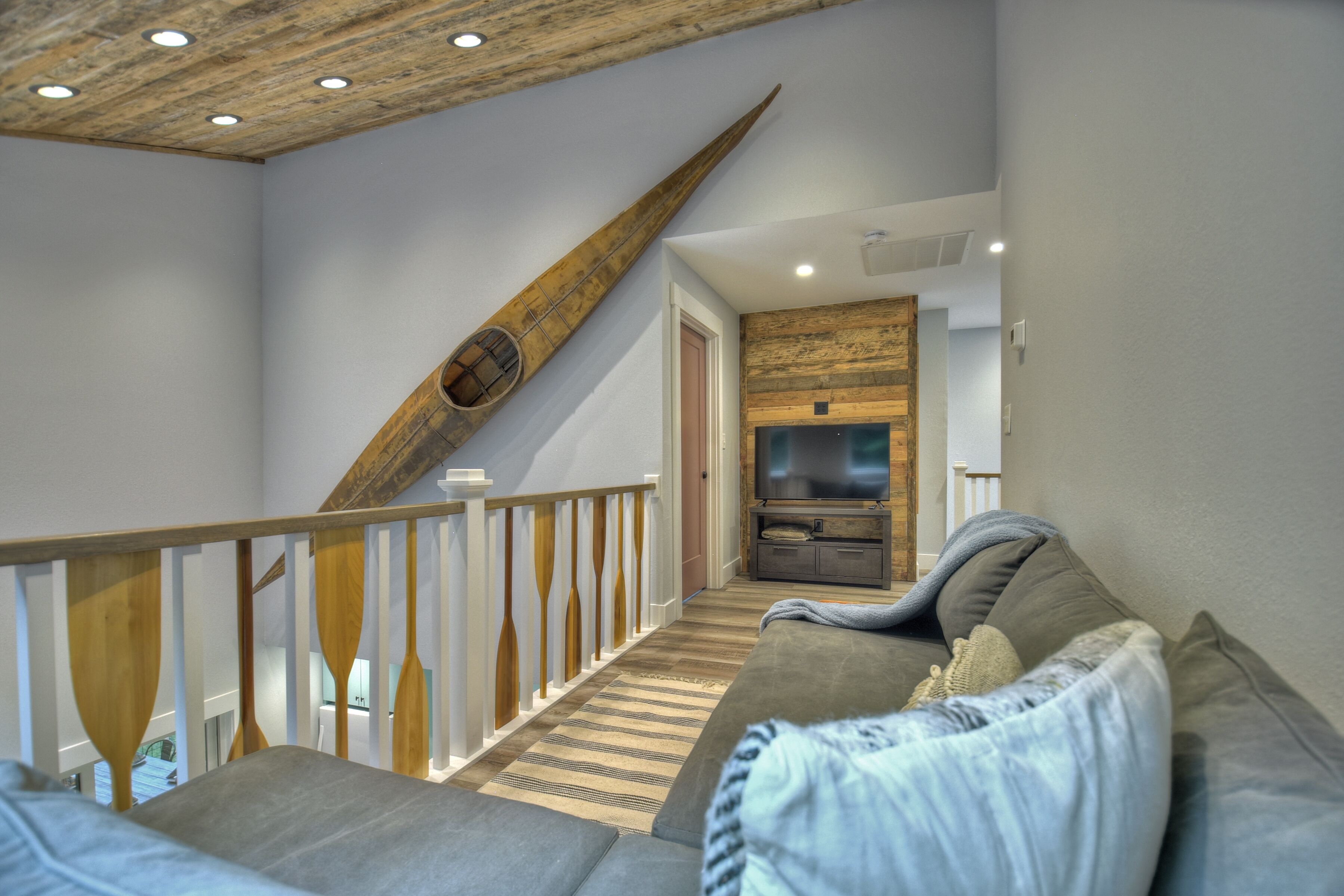 Ein modernes Interieur mit einer Holztreppe, einem grauen Sofa und einer Küchenzeile.