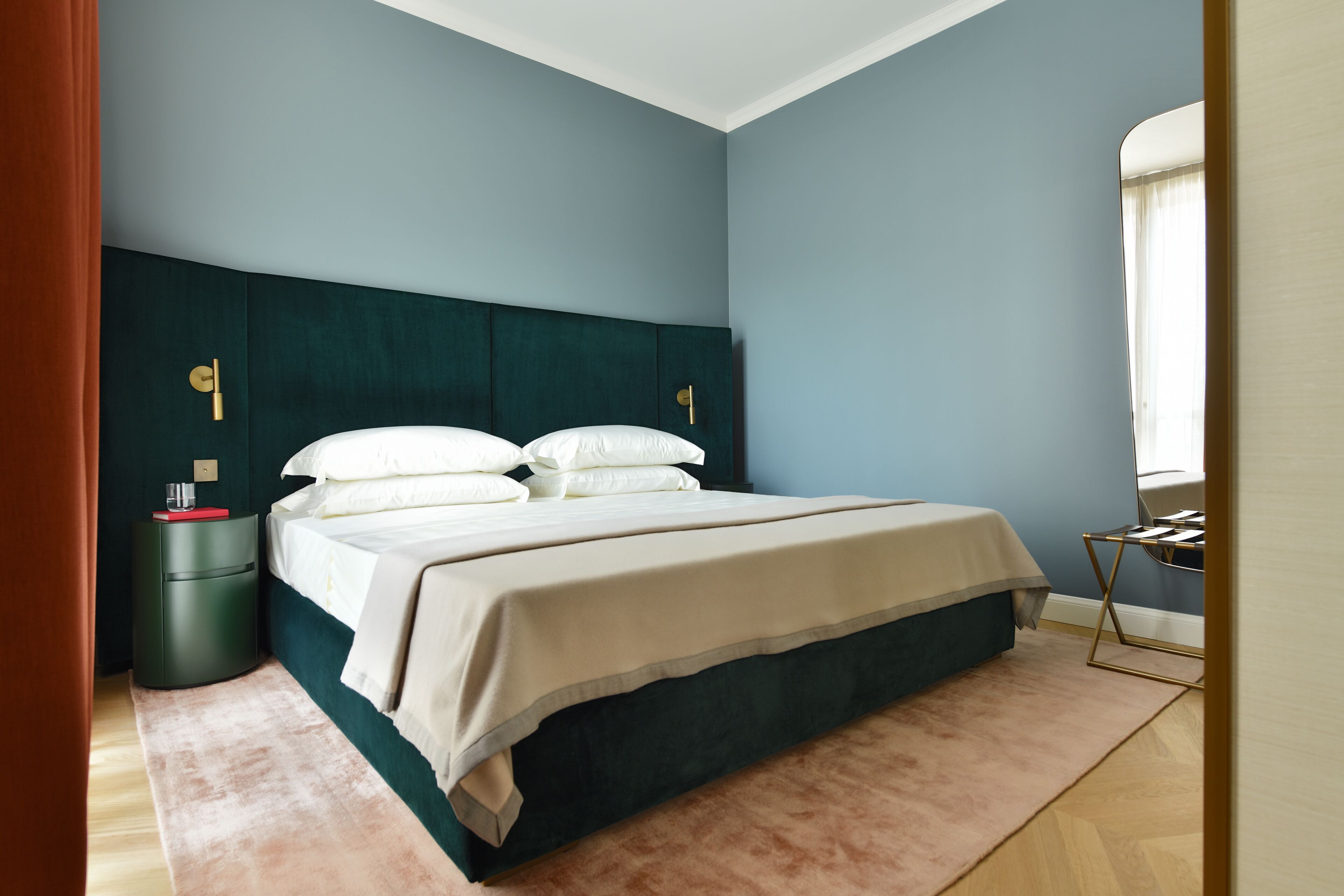 A bedroom with a bed, nightstand, and a window.