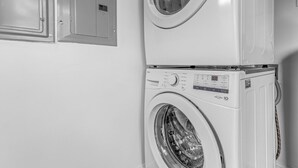 Una lavadora y secadora apiladas en un cuarto de lavado.