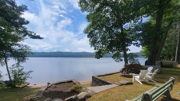 A lakeside outdoor seating area with a fire pit, benches, and Adirondack chairs. - Webster Lake Escape! (Franklin)