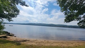 A lake with a sandy shore, surrounded by trees and hills in the background. - Webster Lake Escape! (Franklin)