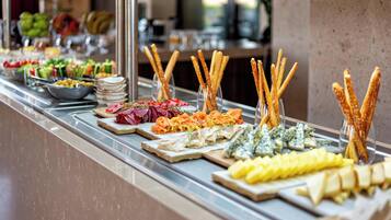 A buffet with various food items including meats, cheeses, and vegetables.