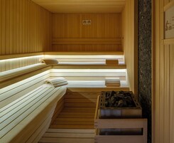 Una sauna con bancos de madera y una pared de piedra.