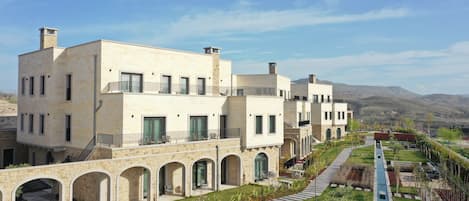 A modern hotel with a courtyard, outdoor seating, and a pool.