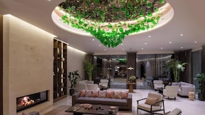 Un salón moderno con chimenea, asientos cómodos y un llamativo techo de vidrio verde.