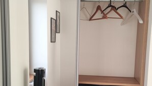 A room with a sliding closet door, a grey chair, and a wooden floor. - Appartement Duplex Dans une Ancienne Usine (Beaupréau-en-Mauges)