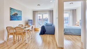 Ein modernes Wohnzimmer mit Essbereich, einer Couch und einem Bett.