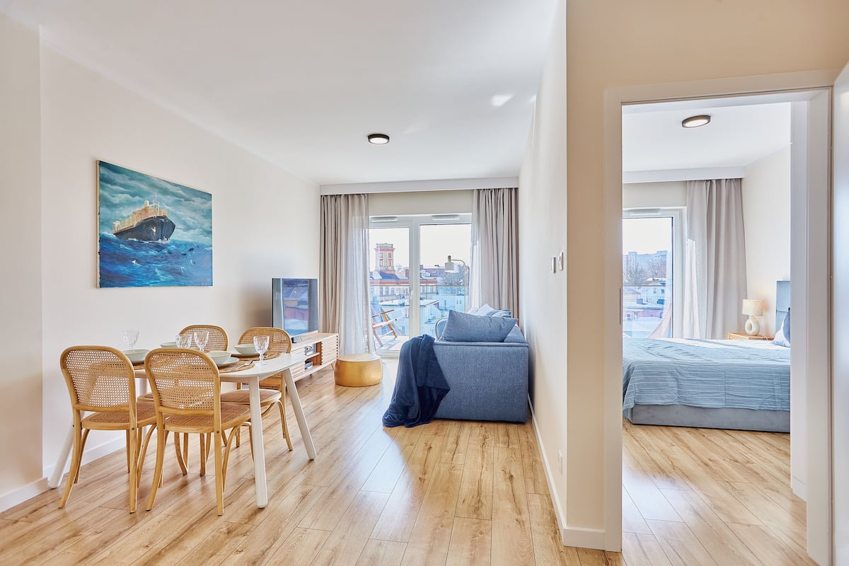 Uma sala moderna com área de jantar, sofá e cama.