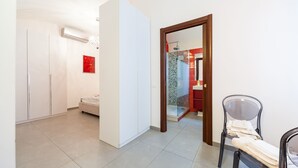 Una habitación de hotel moderna con una cama grande, una silla y un armario.