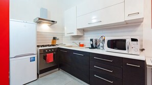 Una cocina moderna con refrigerador, estufa, microondas y gabinetes negros.