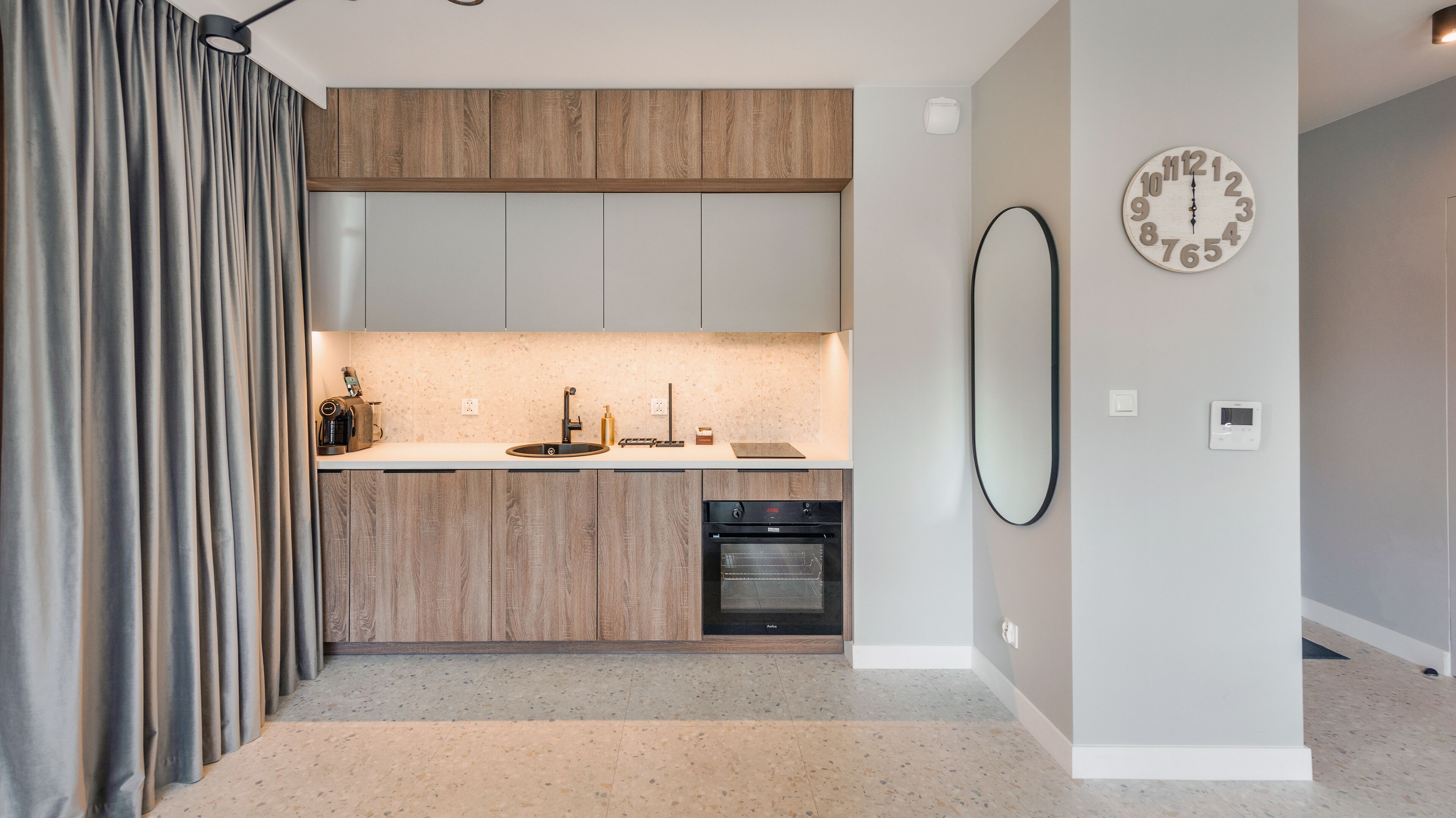 Une cuisine moderne avec des meubles en bois, un four encastré et un évier.