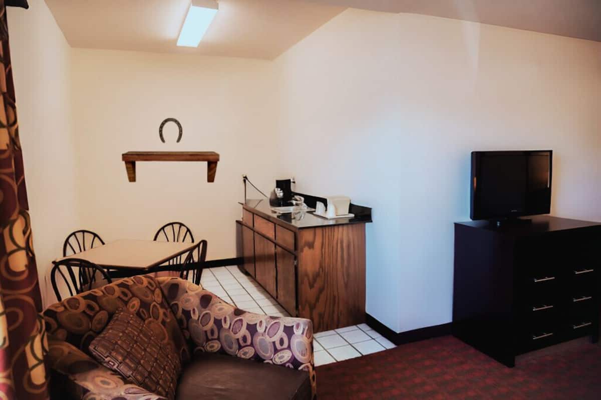Een compacte woonruimte met een kitchenette, een eethoek en een televisie.