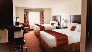 A hotel room with two beds, a desk, a chair, and a television. - OK Welcome Home Hotel (Alva)