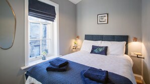 Una camera da letto ben sistemata con un letto grande, una finestra con vista e lampade sui comodini.