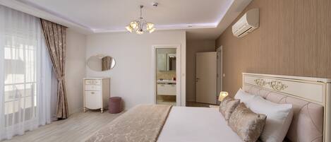 A hotel room with a large bed, a bedside table, a mirror, and a wardrobe.
