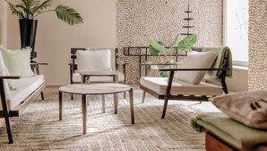 A cozy living room with a sofa, two armchairs, a coffee table, and a potted plant. - INSIDE Nordhorn by Hackmann (Nordhorn)