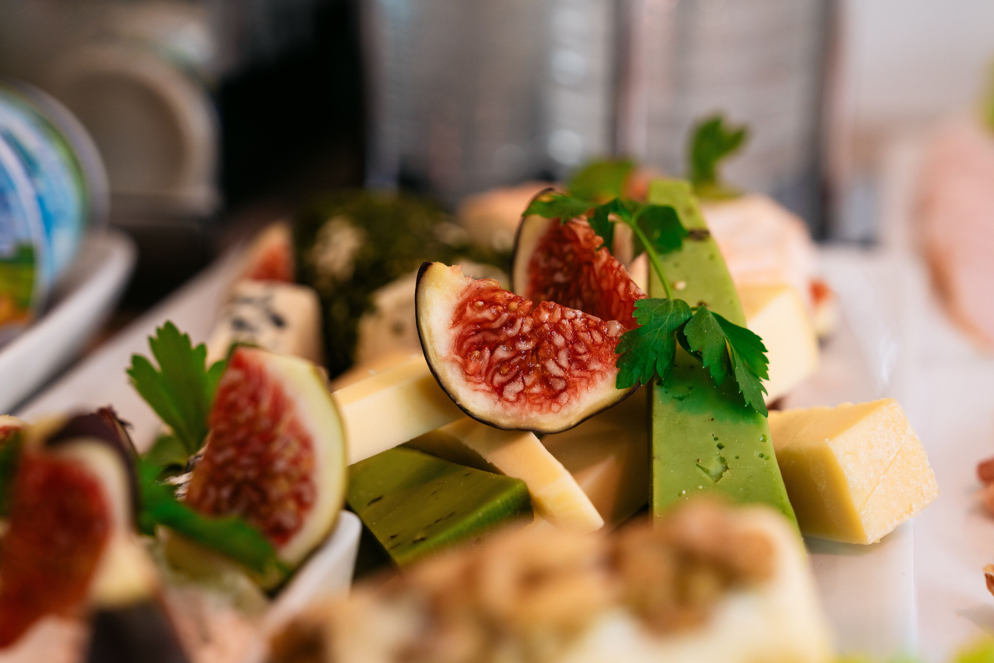 A variety of cheeses and fruits, including figs and possibly other fruits, arranged on a platter.