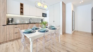 A modern kitchen with a white countertop, wooden cabinets, and a built-in microwave.