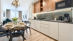 A modern kitchen with a built-in microwave, a coffee maker, and a sink.